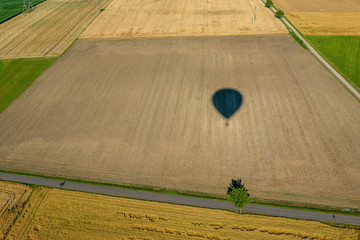 Cień balonu lecącego nad polami z widokiem na horyzont. - obrazy, fototapety, plakaty
