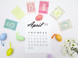 April 2018 calendar, easter eggs and white flowers on a white background