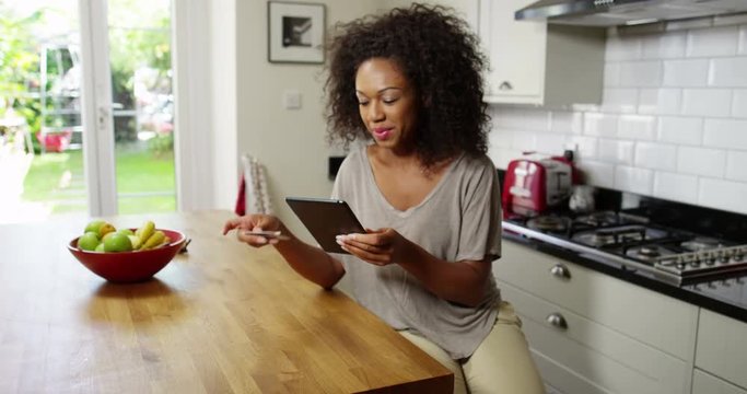 A cheerful woman doing her online shopping on a digital tablet