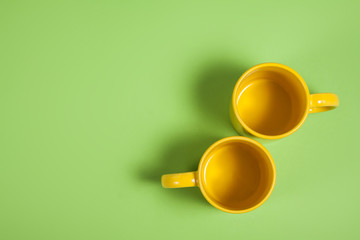 Colorful tea or coffee cups on green background