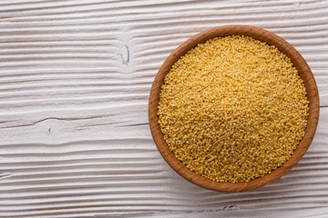 bowl of millet on a white wooden background
