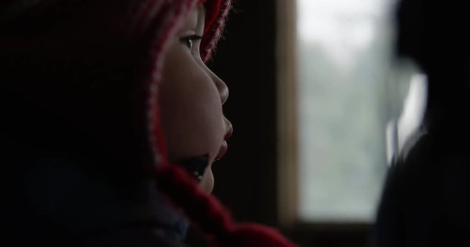 Toddler bundled up in winter warms up in a log cabin