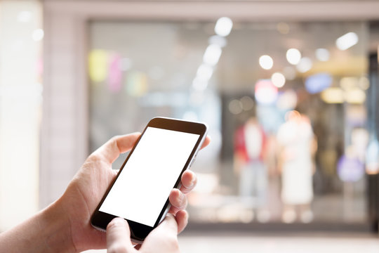 A man using smartphone with blank screen in a market or department store, closeup image. For Graphic display montage.