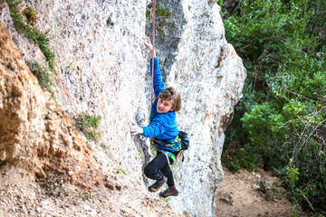 Naklejka premium The boy climbs the rock.