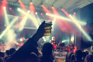 Raised beer glass at a concert.