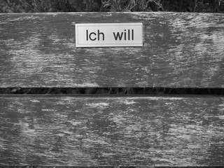 park bench black and white with sign close up