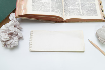 Trouble writing concept. Short Note notebook and open book with rumple paper and pencil