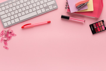 Working space with keyboard on pink background