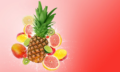 Fresh fruits, pineapple surrounded with grapefruit, lime, kiwi, mango, strawberries in water splash, isolated on red background with free space