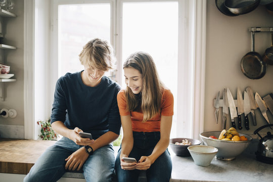 Teenage couple using smartphones