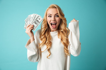 Portrait of an excited young blonde woman in sweater