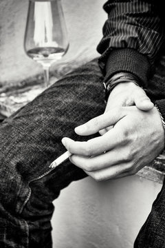 Hands, cigarette and glass of wine