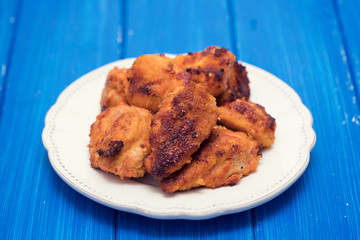 fried chicken on white plate on wooden background
