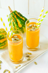 Healthy pumpkin smoothie with seeds in glasses on white background