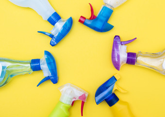Spring cleaning spray bottle products on a bright yellow background