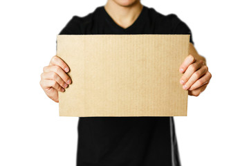 A young guy in a black t-shirt holding a piece of cardboard. Prepared for your text. Isolated on white background