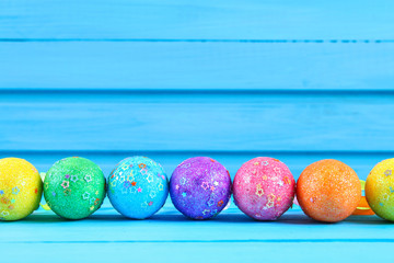 Colorful easter egg on blue pastel color wood background with space