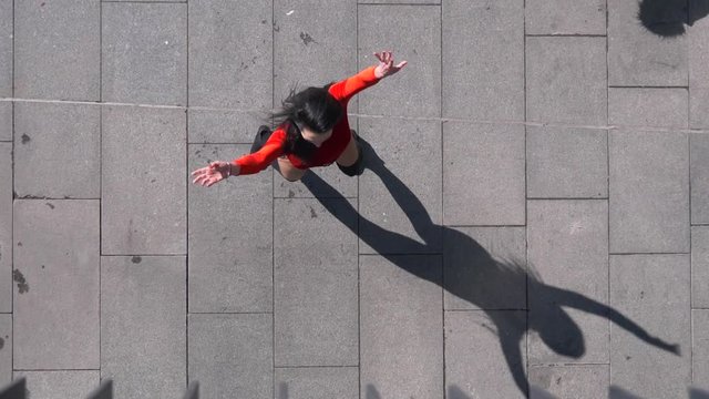 View from above of sexy female dancer in Vogue and Waacking dance style dancing in the city with urban background.
