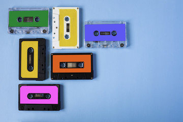 Retro cassette tape collection on blue background, top view, copy space.