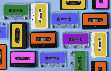 Retro cassette tape collection on blue background, top view.