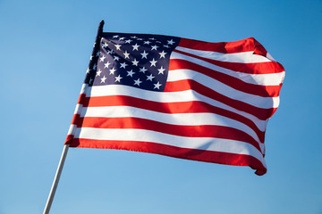 American flag waving on blue sky background