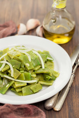 boiled green beans with onion on white plate