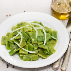 boiled green beans with onion on white plate