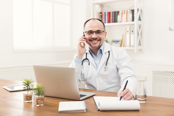 Happy doctor talking on phone with his patient - obrazy, fototapety, plakaty