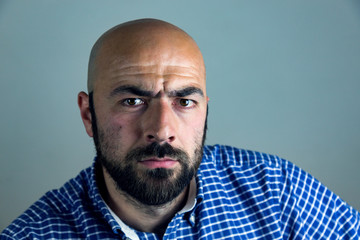 Obraz premium Portrait of bald man with beard in studio.Man showing different emotions.