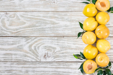 Golden plums on wooden board.Top view, copy space.