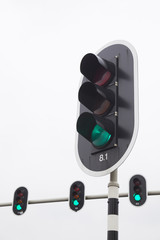 closeup of green traffic lights and overcast sky