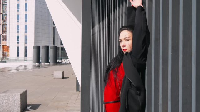 Sexy female dancer in Vogue and Waacking dance style dancing in the city with urban background.