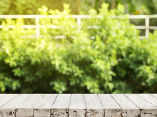 Empty wood table top on blur abstract green from garden and house background