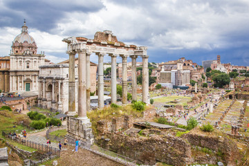 Fototapeta na wymiar Panoramic view of Roman Forum with ancient ruins of temple, columns of Saturn, Triumphal Arch of Septimius Severus, Rome, Italy
