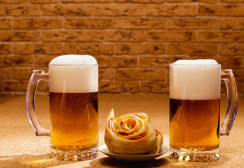 Two pints of lager and plates of appetizers are on the table.