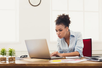 Serious business woman working on laptop at office