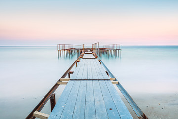 Long esposure view of a old jetty in a calm sea with gentle sky, soft colors - Powered by Adobe