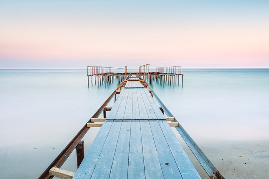 Long esposure view of a old jetty in a calm sea with gentle sky, soft colors