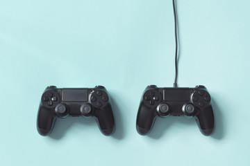 Gamepad connected wire from the game console on blue background. Concept of competition, game tournaments. © Olha Kozachenko