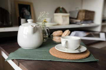 Still life in the kitchen in the morning a cup with tea kettle and biscuits and magazines