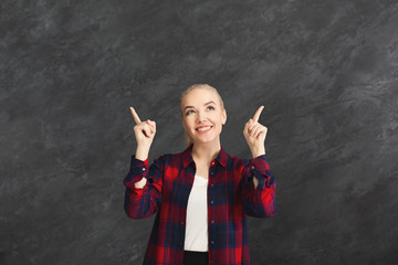 Excited woman shows something, point fingers up