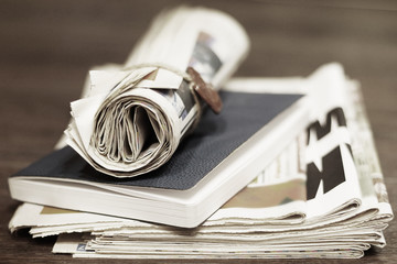 Newspapers and notebook. Pile of daily papers, book for notes and rolled paper with news. Pages with headlines and articles, concept for business and work at the office. Paperwork on the desk