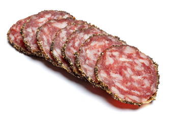 Dried organic salami sausage covered with pepper on white background