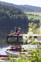 Junges Paar entspannt auf einem Bootssteg