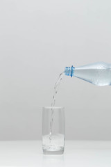 Water is poured in a glass in a studio