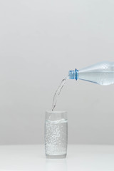 Water is poured in a glass in a studio