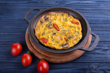 Omelette on an iron frying pan. Dish for the restaurant