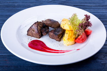 Fried beef liver with herbs, spices and sauce on a plate