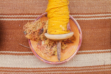 Spindle with alpaca wool dyed yellow seen from above