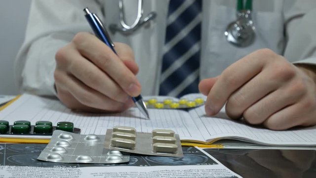male doctor fills out the registrations at the table